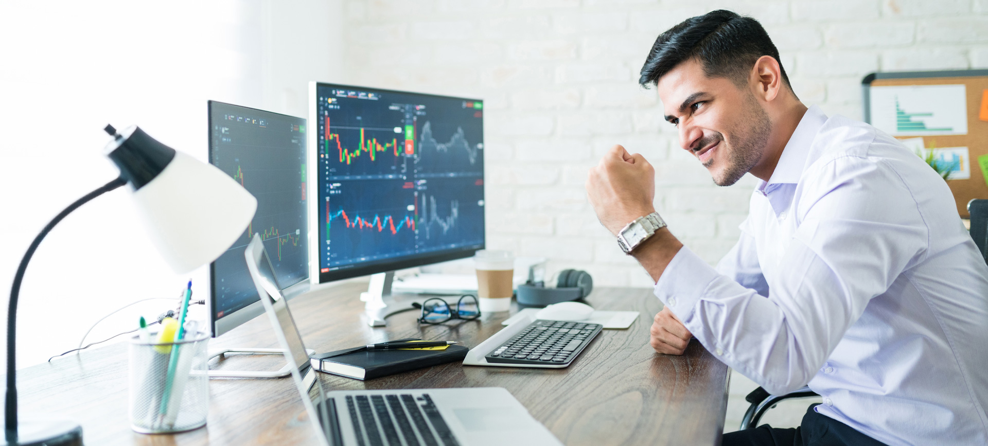 confident-handsome-hispanic-financial-broker-showing-fist-computer-screen-while-trading-from-home